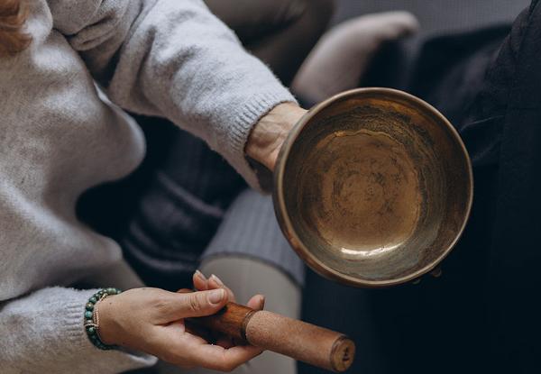 A person holding a singing bowl, preparing for a Reiki healing session.
