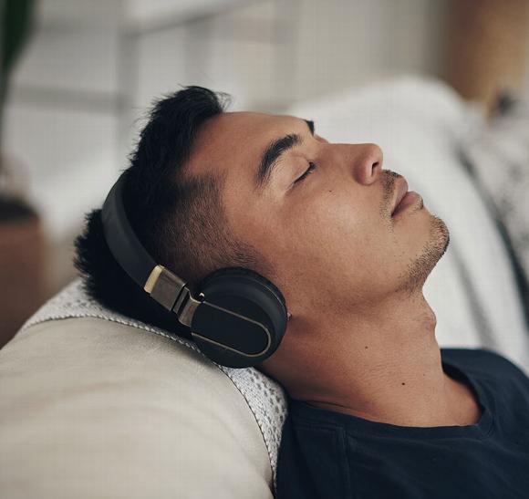 A person relaxing with headphones, reflecting a calming environment for animal healing.